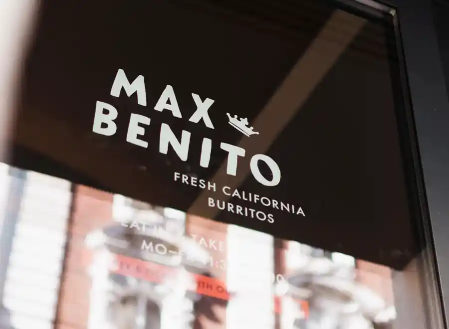 Foto des Max & Benito Logos an einer Glastüre